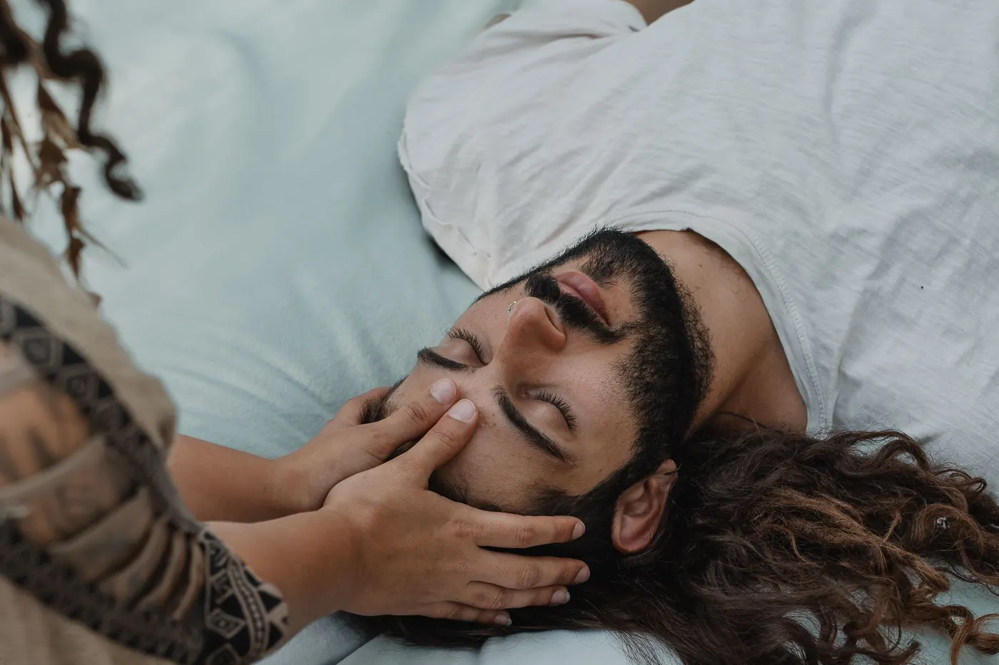 ידיים מרגיעות את פניו של משתתף בסשן פרטני